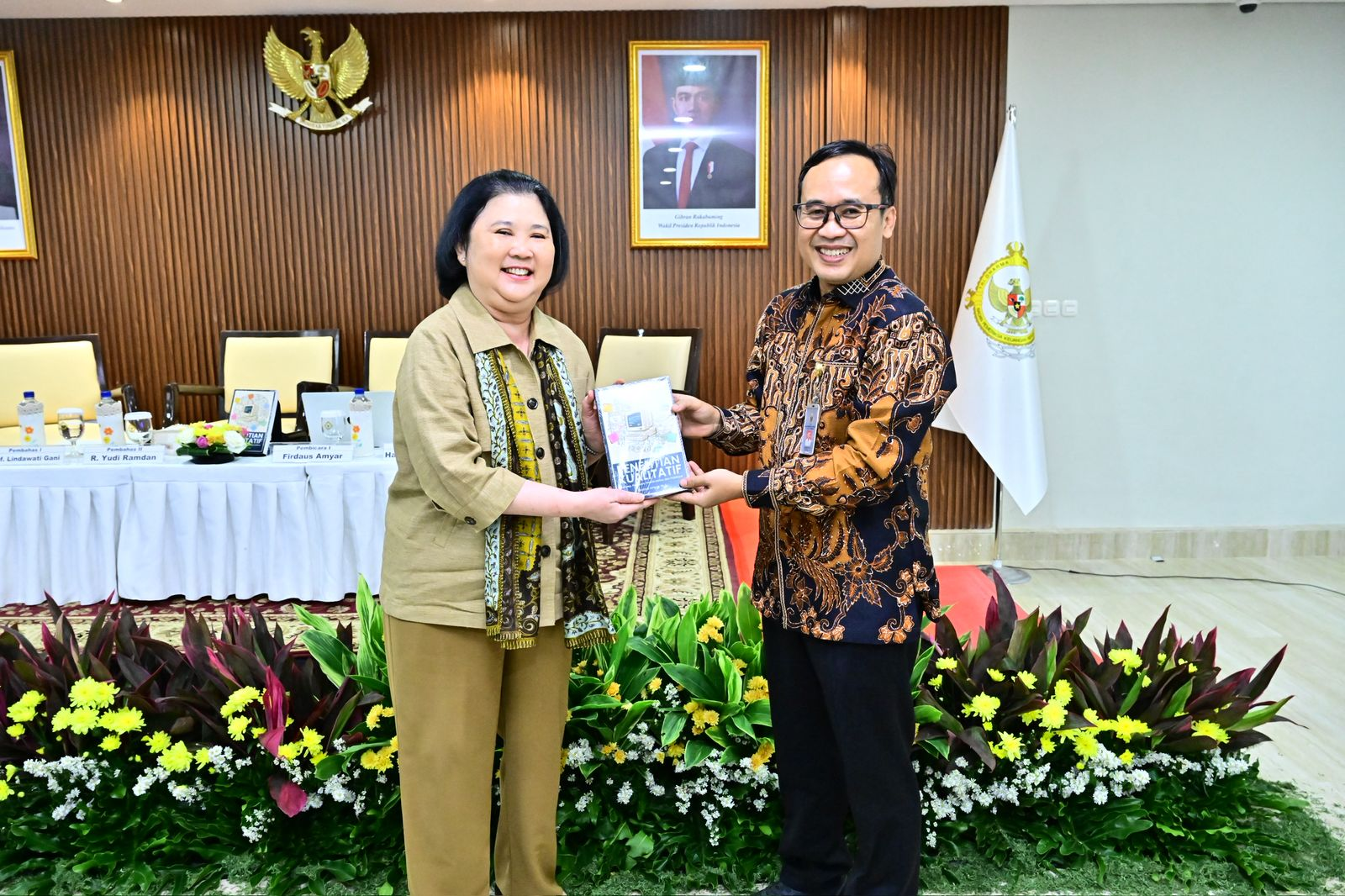 Firdaus Amyar menyerahkan buku Penelitian Kualitatif kepada Prof Lindawati Gani pada sesi Bedah Buku di BPK.